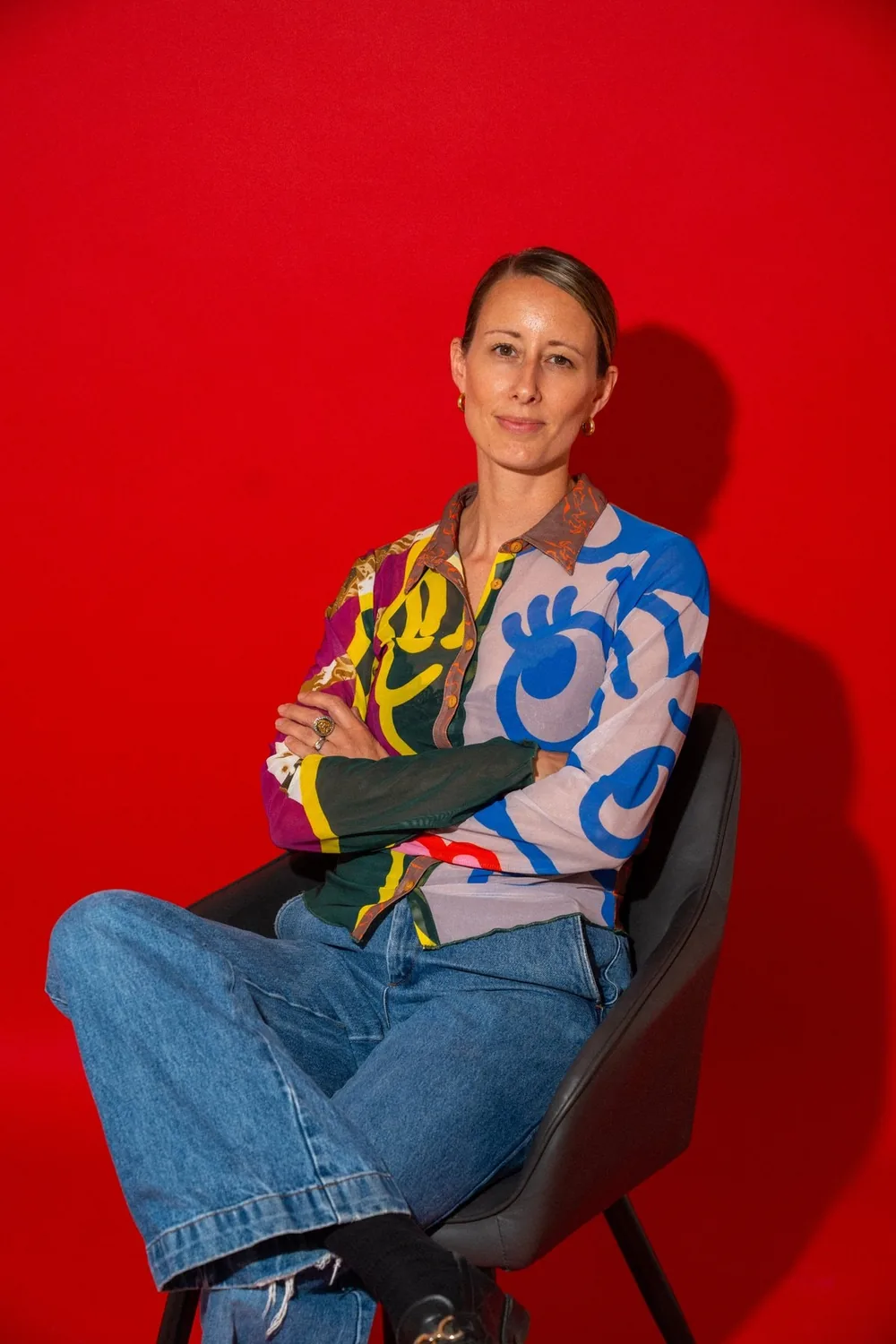 Lucie Watson, founder of goodtwin, sitting against a red wall